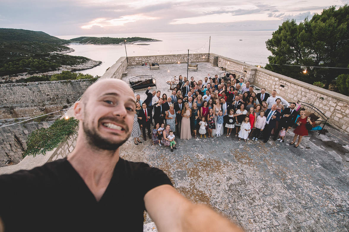 Photographer taking selfie with wedding guests on the roof at Fort George